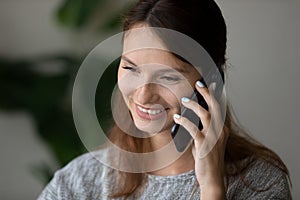 Happy millennial lady enjoying chatting with friends, mobile conversation.