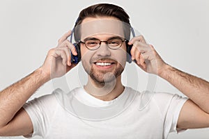 Happy millennial man listen to music in new Bluetooth headphones