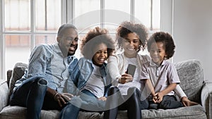 Happy millennial parents and children using smartphone