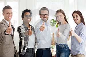 Happy millennial people standing showing thumbs up photo