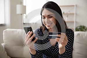 Happy Vietnamese woman shopping online on cellphone