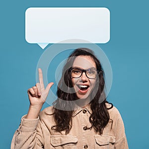 Happy millennial woman in glasses showing empty white speech balloon