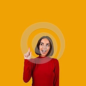 Happy millennial woman pointing upwards showing eureka gesture