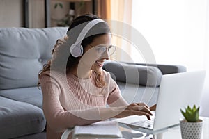 Happy millennial woman student in glasses studying on online courses.