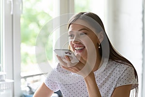 Happy millennial woman talk on cell on loudspeaker