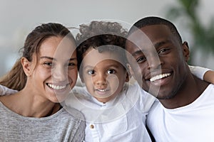 Happy mixed ethnicity family with cute kid son bonding, portrait