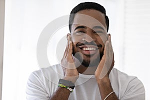 Happy mixed race African man touching soft stubble, stylish beard photo