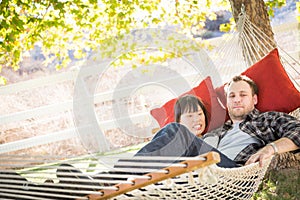 Happy Mixed Race Chinese and Caucasian Couple Relaxing in a Hammock Outside