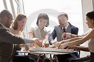 Happy mixed race company workers sharing lunch, eating pizza.