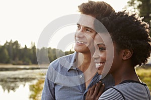 Happy mixed race couple admiring a view in the countryside photo