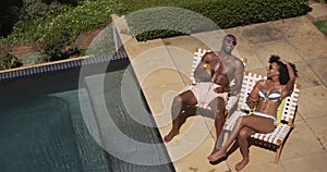Happy mixed race couple enjoying the pool during a sunny day
