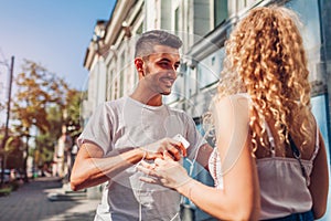 Mixed race couple in love listening to the music on phone and dancing on city street using earphones.