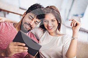 Happy mixed race couple shopping online at home