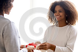 Happy mixed race daughter giving present to beloved mother