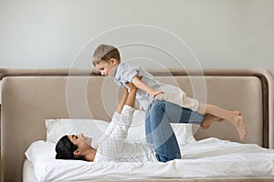Happy mixed race family doing balance exercises in bedroom.