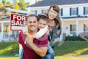 Happy Mixed Race Family In Front of House and For Sale Real Estate Sign