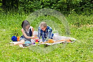 Happy Mixed Race Family Having a Picnic and Playing In The Park