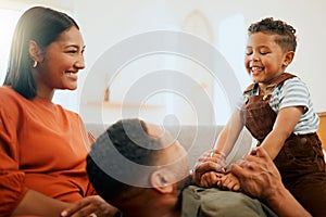 A happy mixed race family of three relaxing in the lounge and being playful together. Loving black family bonding with