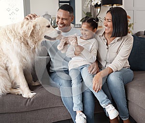 A happy mixed race family of three relaxing on the sofa with their dog. Loving black family being affectionate with a