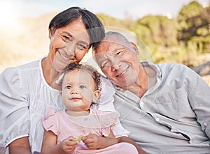 Happy mixed race grandparents sitting with granddaughter on a beach. Adorable, happy, hispanic baby girl bonding with