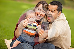 Happy Mixed Race Parents and Baby Boy with Camera