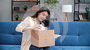 Happy mixed race woman open cardboard box marketplace order desired package enjoy online shopping