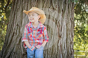 Happy Mixed Race Young Boy Wearing Cowboy Hat Standing Outdoors.