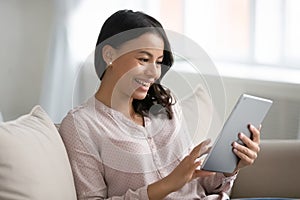 Happy mixed raced woman using tablet for video call