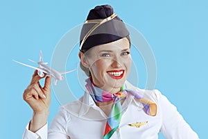 happy modern female air hostess on blue in uniform