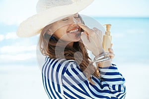 happy modern female on beach with sunscreen