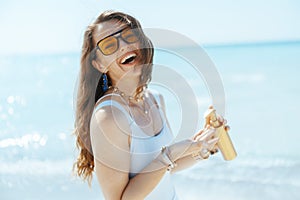 happy modern female on ocean shore with spf