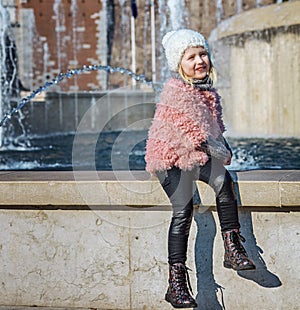 Happy modern girl in Milan, Italy playing near fontain