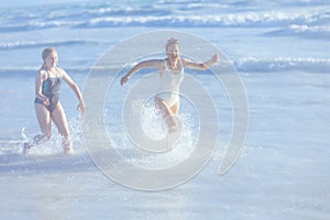 happy modern mother and teenage daughter at beach running