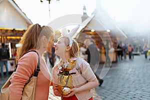 Happy modern mother and teenage daughter at fair in city