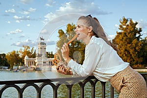 Tourist woman in Madrid, Spain eating traditional Spain churro photo