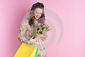 Happy modern woman in floral dress on pink