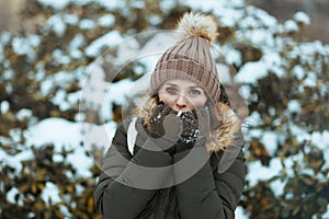 happy modern woman warming cold hands with breath