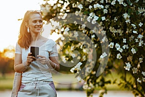 happy modern woman in white shirt using smartphone