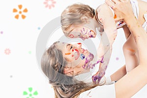 Happy mom and baby playing with painted face by paint