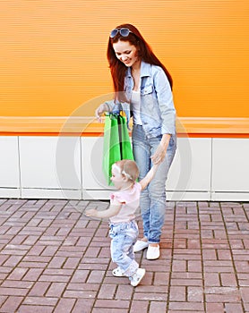Happy mom and baby with shopping bags walking
