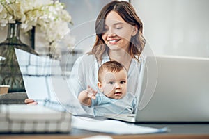 Happy mom with baby working at laptop