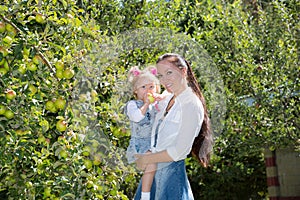 Happy mom and child girl hugging on nature. Beautiful Mother and her baby outdoor