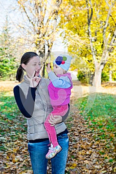 Happy mom and child girl hugging on nature at fall. The concept of childhood and family.