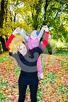 Happy mom and child girl hugging on nature at fall. The concept of childhood and family.