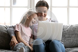 Happy mom and cute gen Z kid watching funny movie