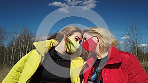 Happy mom and doughter in masks outdoors