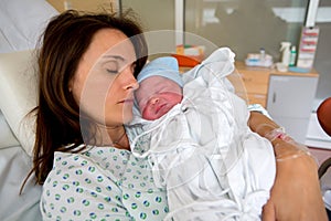 Happy mom, having her baby skin to skin first seconds after birth