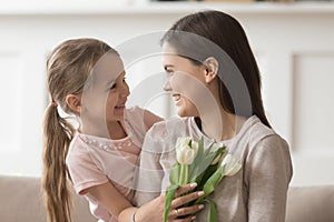 Happy mom holding flowers mothers day gift from cute kid
