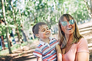 Happy mom laughing with her little son in her arms.