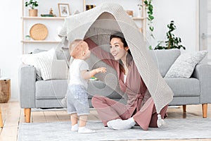 Happy Mom Playing With Toddler Son At Home, Peeking From Under Blanket